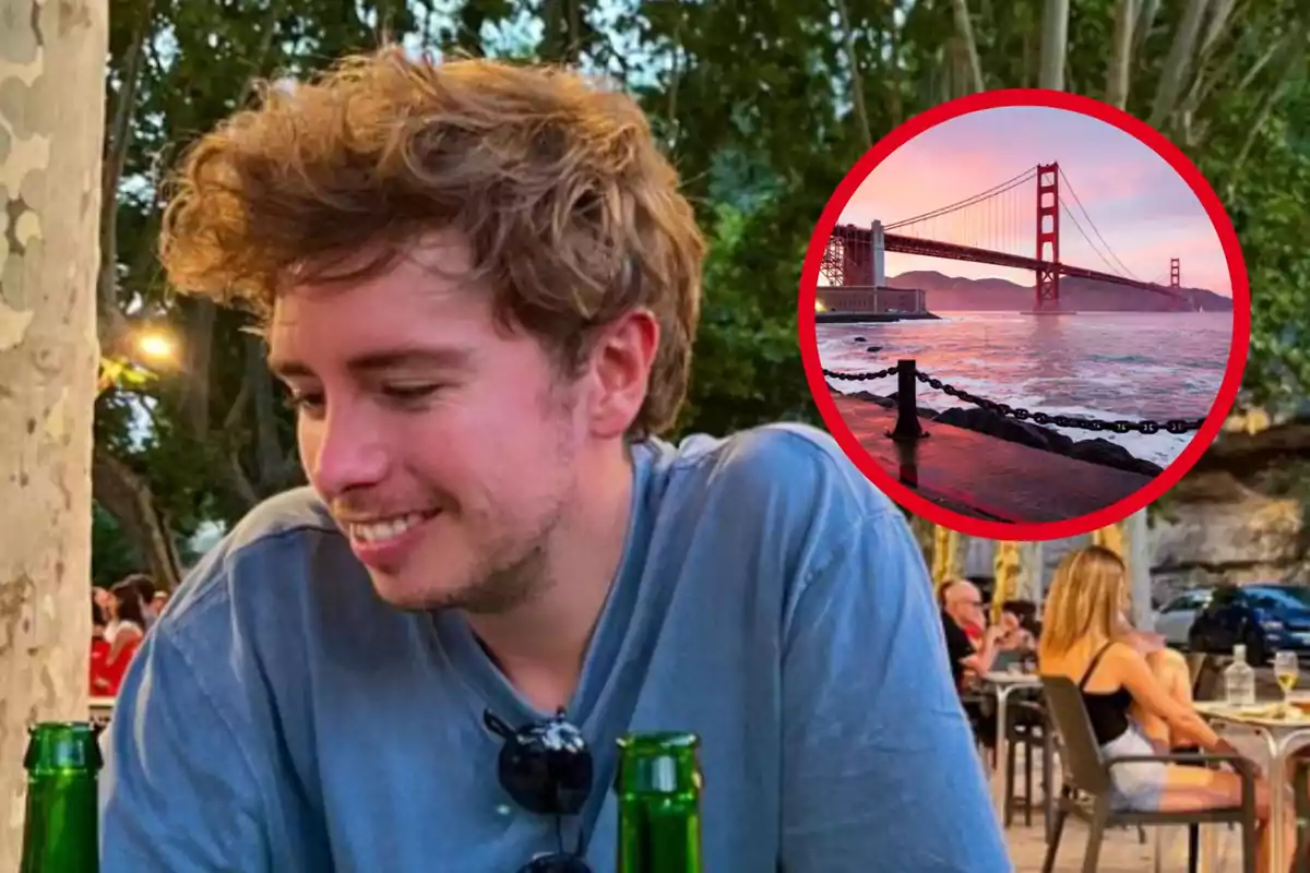 Un home somrient amb una samarreta blava està assegut a l'aire lliure en un cafè, amb una imatge del pont Golden Gate en un cercle vermell superposada a la cantonada superior dreta.