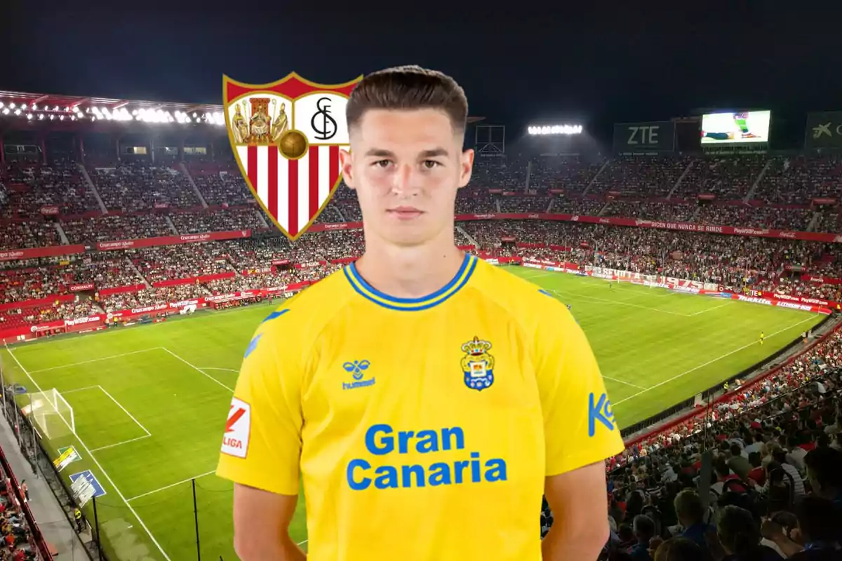 Un jugador de futbol amb la samarreta groga de la UD Las Palmas és en un estadi ple d'espectadors, amb l'escut del Sevilla FC al fons.