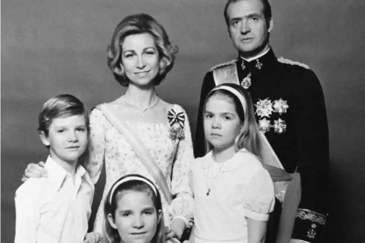 Una familia posando para una fotografía en blanco y negro con un fondo liso.