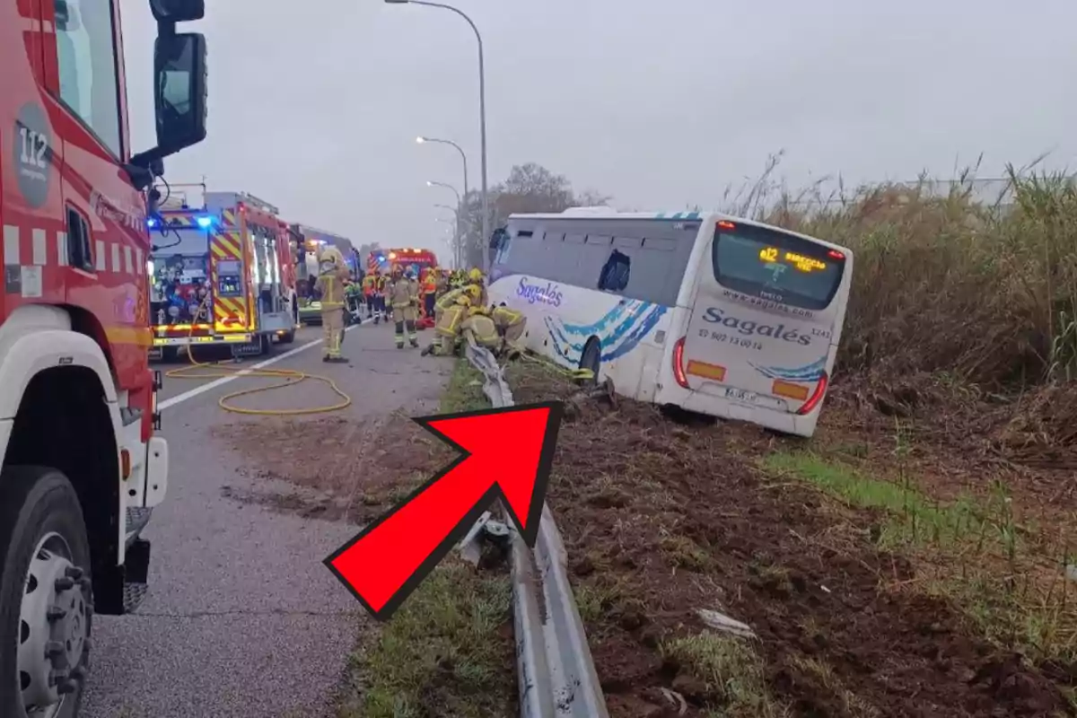 Un autobús accidentado en la cuneta de una carretera con vehículos de emergencia y bomberos trabajando en el lugar.