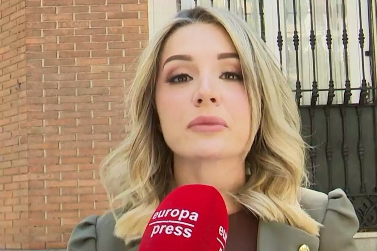 Beatriz Uriarte rossa sostenint un micròfon vermell d'Europa Press davant d'un edifici de maons. Beatriz Uriarte rossa sostenint un micròfon vermell d'Europa Press davant d'un edifici de maons.