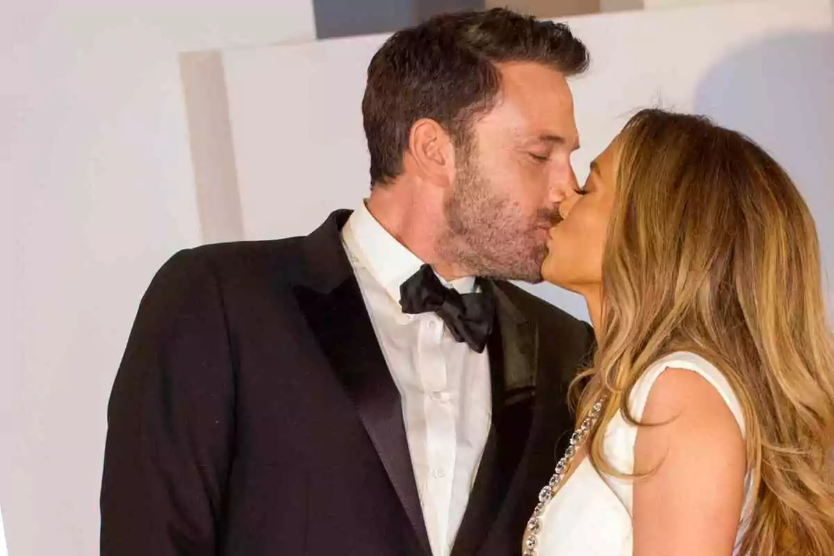 Jennifer López i Ben Affleck elegantment vestits compartint un petó. Jennifer López i Ben Affleck elegantment vestits compartint un petó.