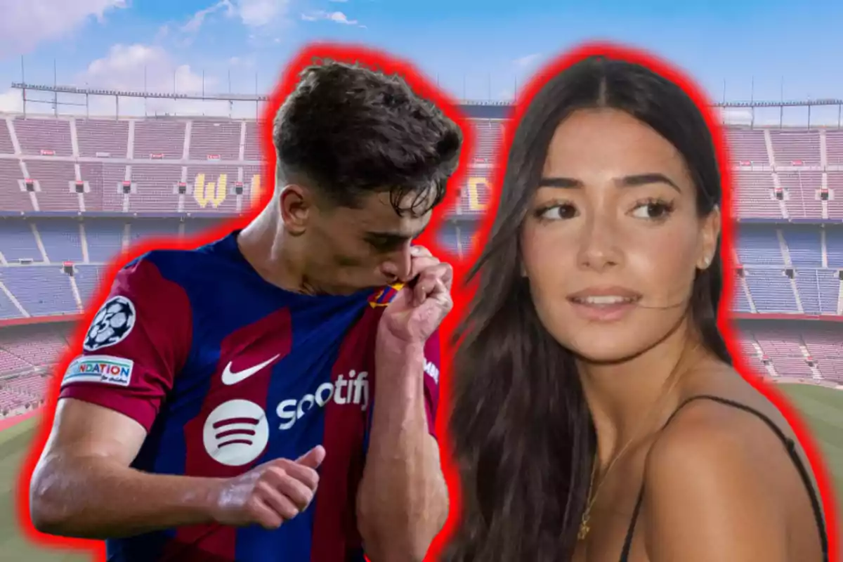Un jugador de fútbol besa el escudo de su camiseta mientras una mujer lo observa en un estadio.