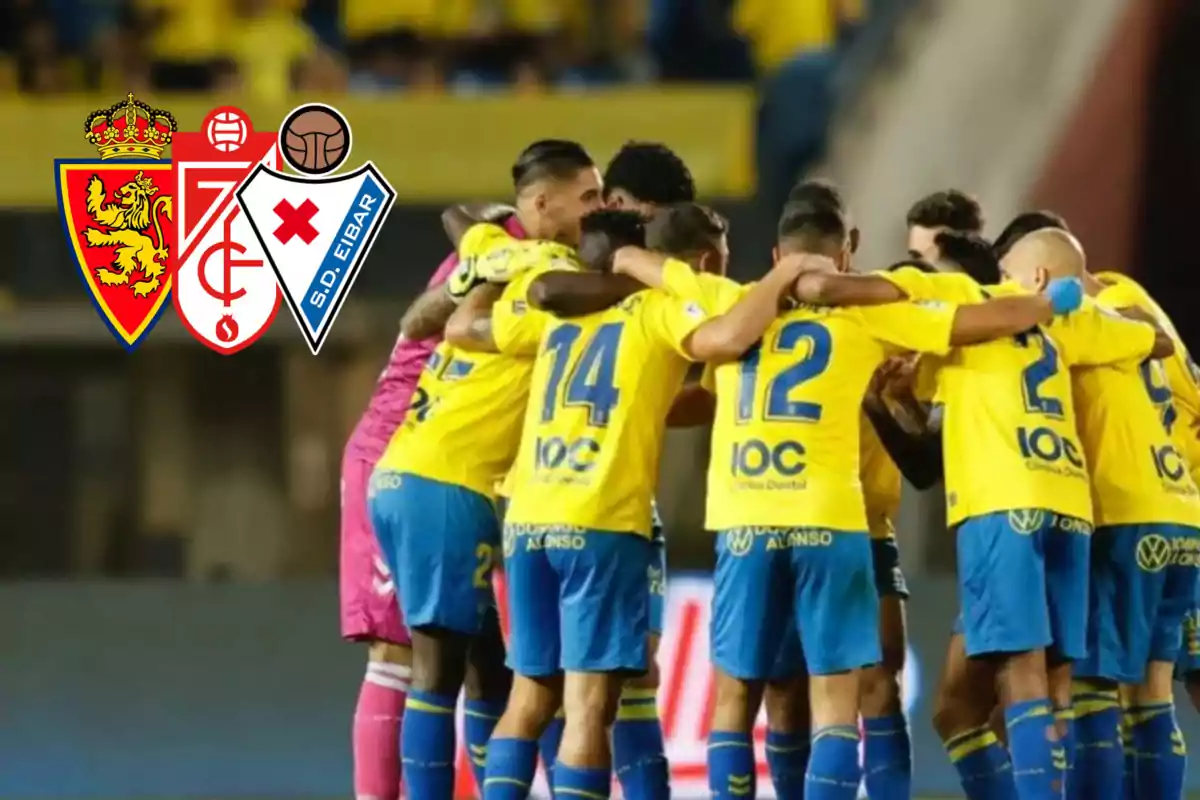 Jugadors de la UD Las Palmas celebrant un gol i escuts de Real Zaragoza, Granada i Eibar