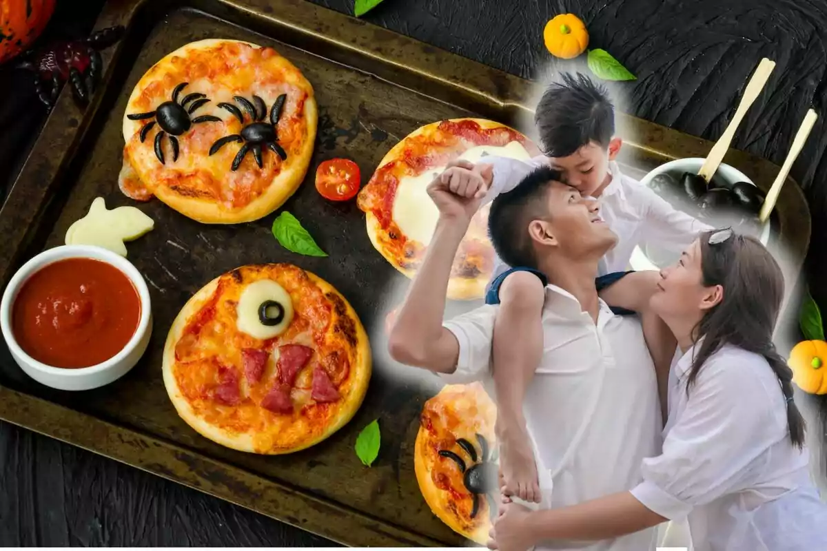 Una família somrient gaudeix d'un moment junts mentre en una safata s'hi veuen mini pizzes decorades amb motius de Halloween, com aranyes fetes d'olives i una salsa de tomàquet al costat.