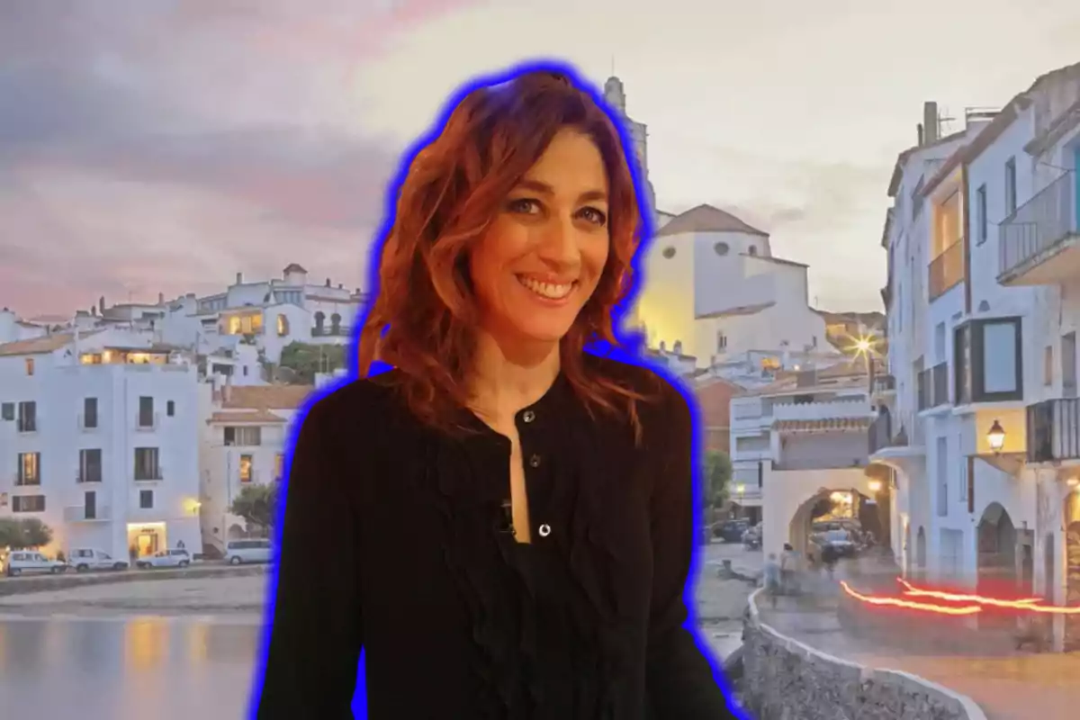 Una persona sonriendo con un fondo de un pueblo costero al atardecer.