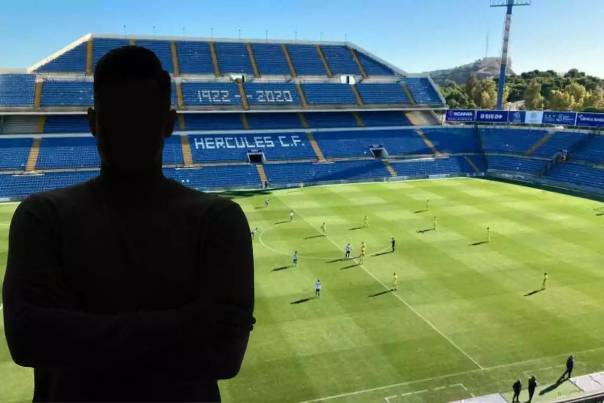 Persona en silueta frente a un estadio de fútbol vacío con el nombre "Hércules C.F." en las gradas.