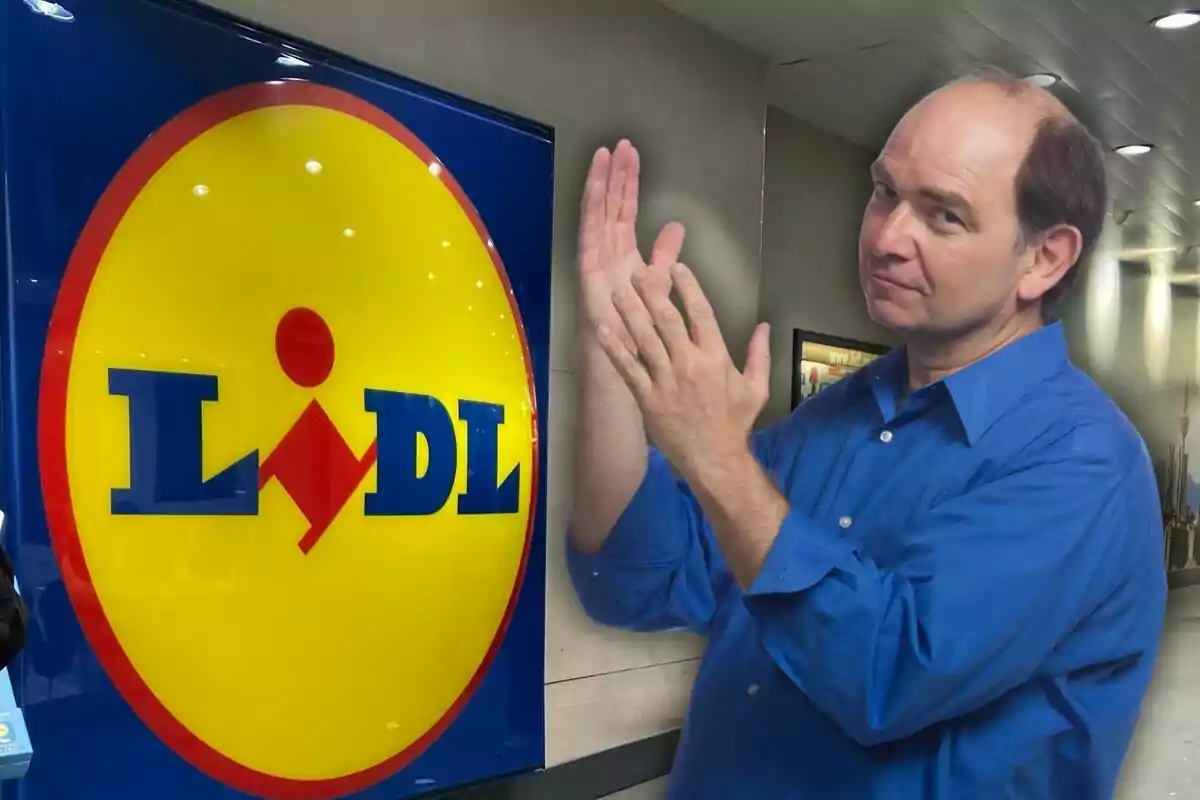 A man in a blue jersey clapping in front of a Lidl sign in an indoor setting.