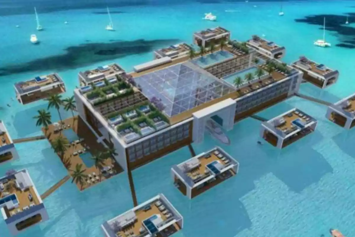 Complex hoteler flotant de luxe amb bungalous sobre l'aigua i les piscines, envoltat d'un mar turquesa amb iots i velers.