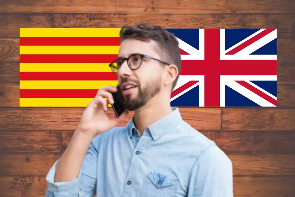 Hombre hablando por teléfono frente a las banderas de Cataluña y Reino Unido