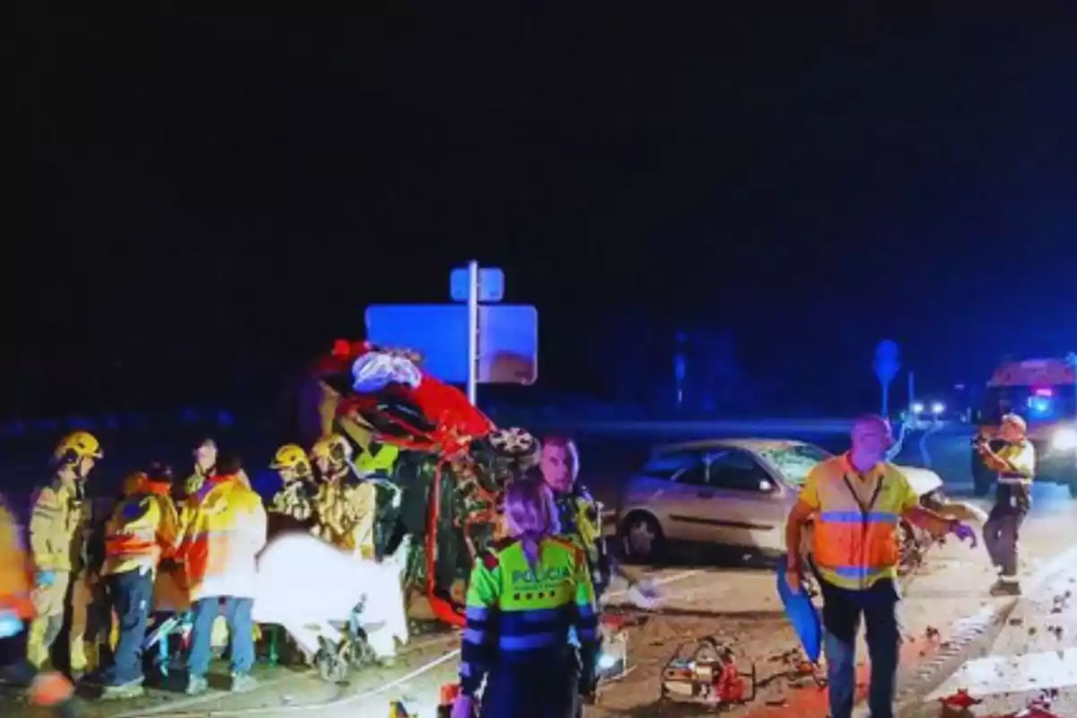 Accidente de tráfico nocturno con presencia de bomberos, policías y paramédicos.