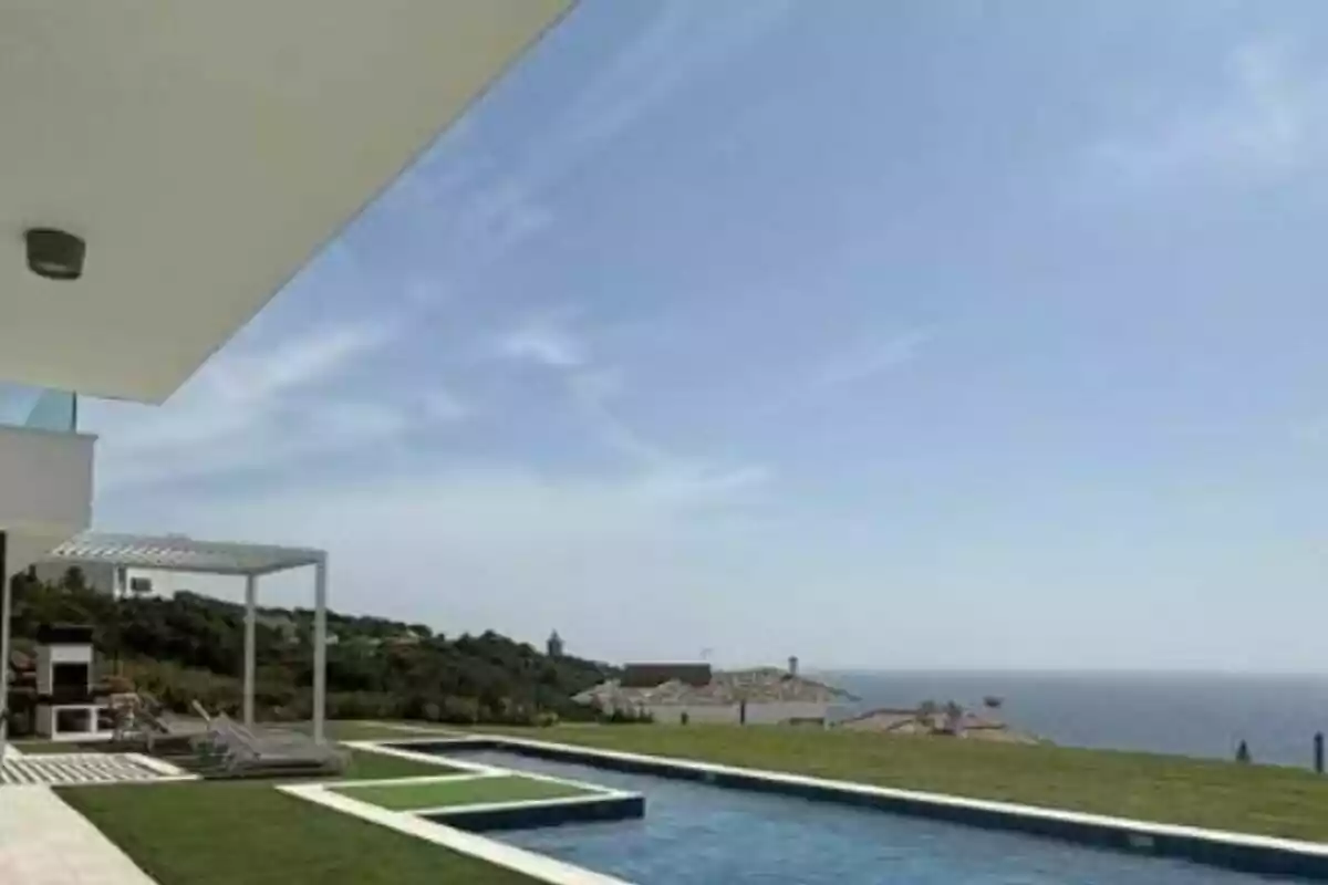 Casa moderna amb piscina i vista al mar en un dia assolellat Casa moderna amb piscina i vista al mar en un dia assolellat