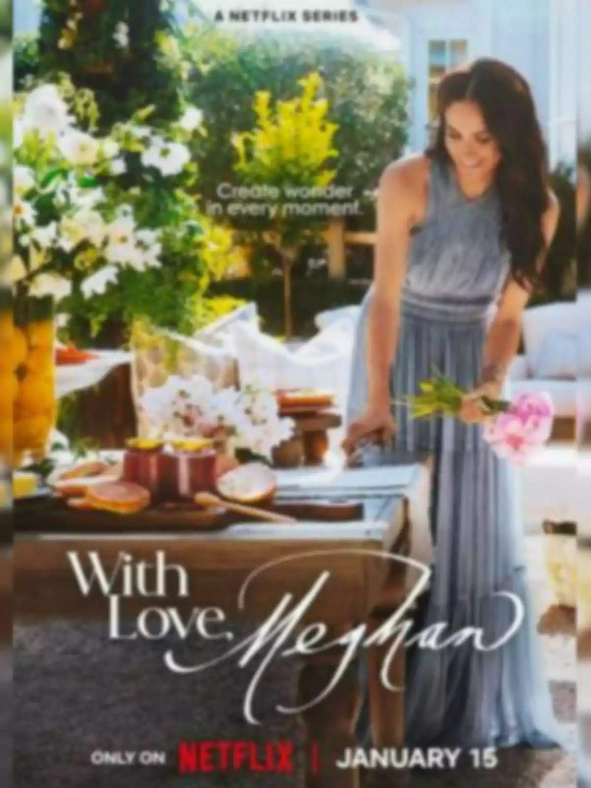 Meghan Markle con un vestido azul claro está de pie junto a una mesa decorada con flores y comida en un jardín, con el texto 