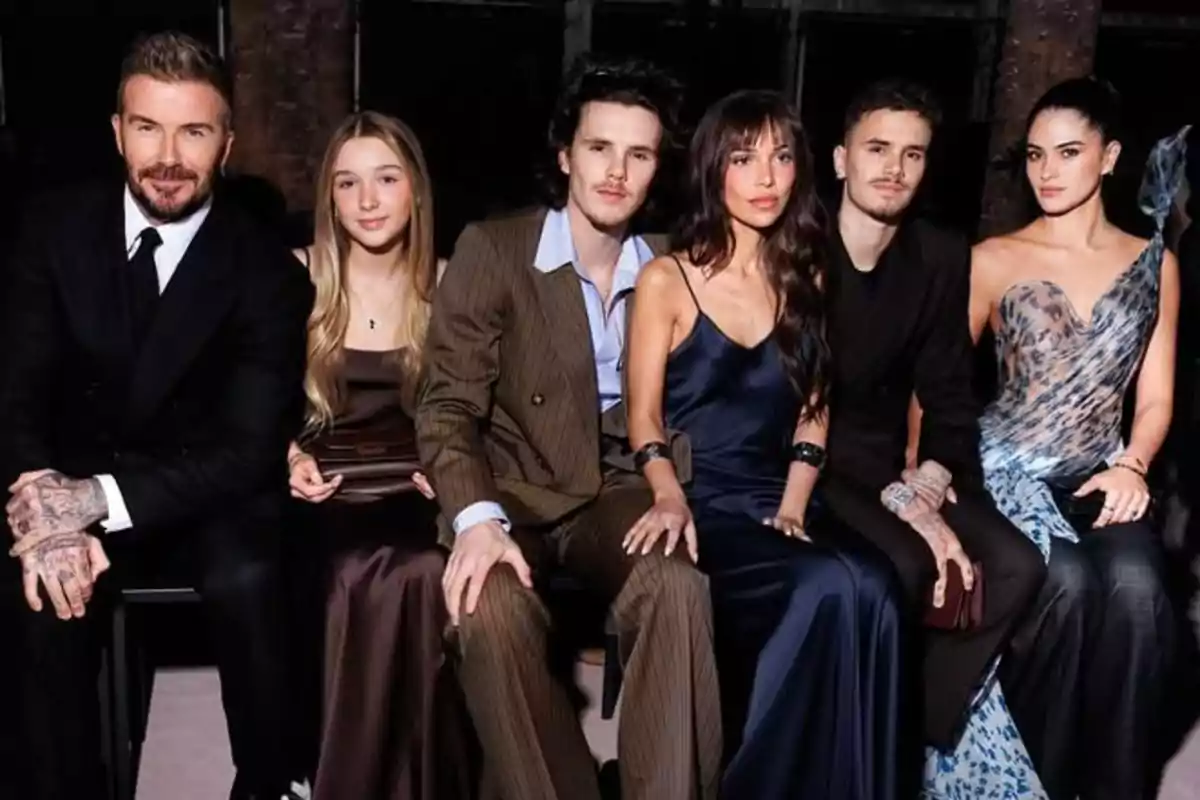 A group of elegantly dressed people posing together at an event. A group of elegantly dressed people posing together at an event.