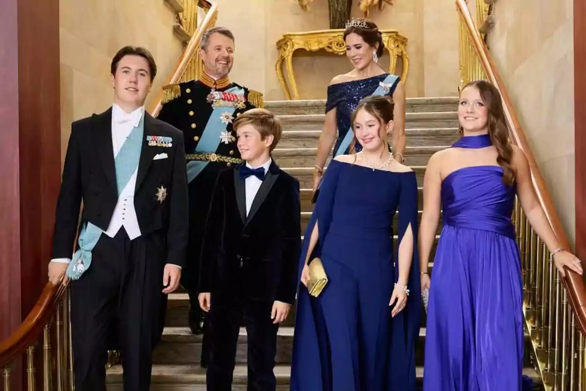A group of elegantly dressed people descends a staircase in a luxurious setting. A group of elegantly dressed people descends a staircase in a luxurious setting.