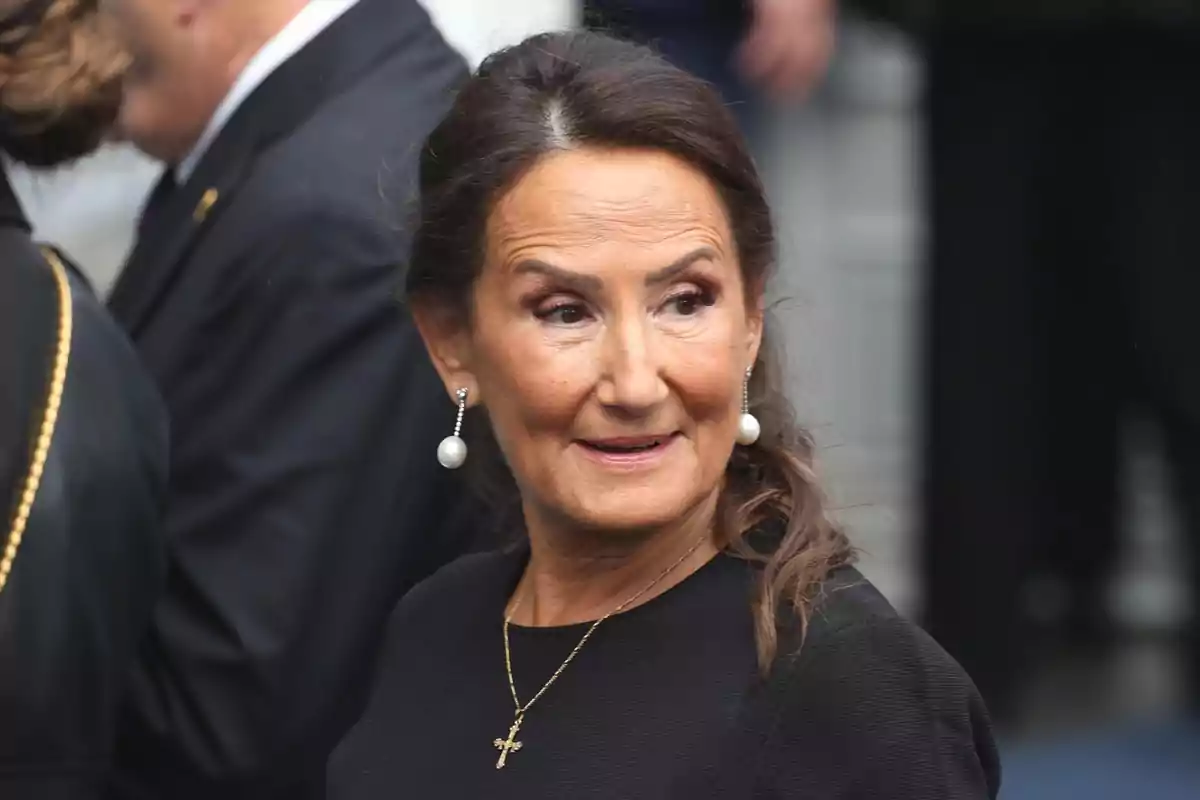 Dona amb cabell recollit i arracades de perles en un esdeveniment formal. Dona amb cabell recollit i arracades de perles en un esdeveniment formal.