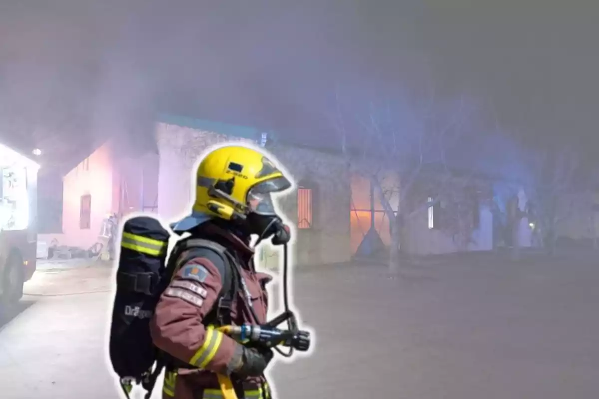 Bombero con equipo de protección frente a un edificio en llamas y rodeado de humo