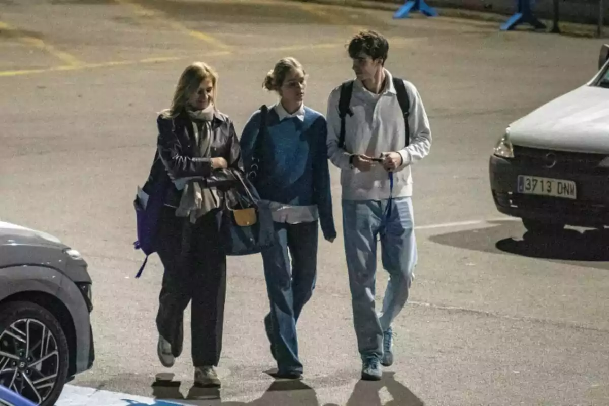 Infanta Cristina, Irene Urdangarin and Pablo Urdangarin walking together in a parking lot lit up at night. Infanta Cristina, Irene Urdangarin and Pablo Urdangarin walking together in a parking lot lit up at night.