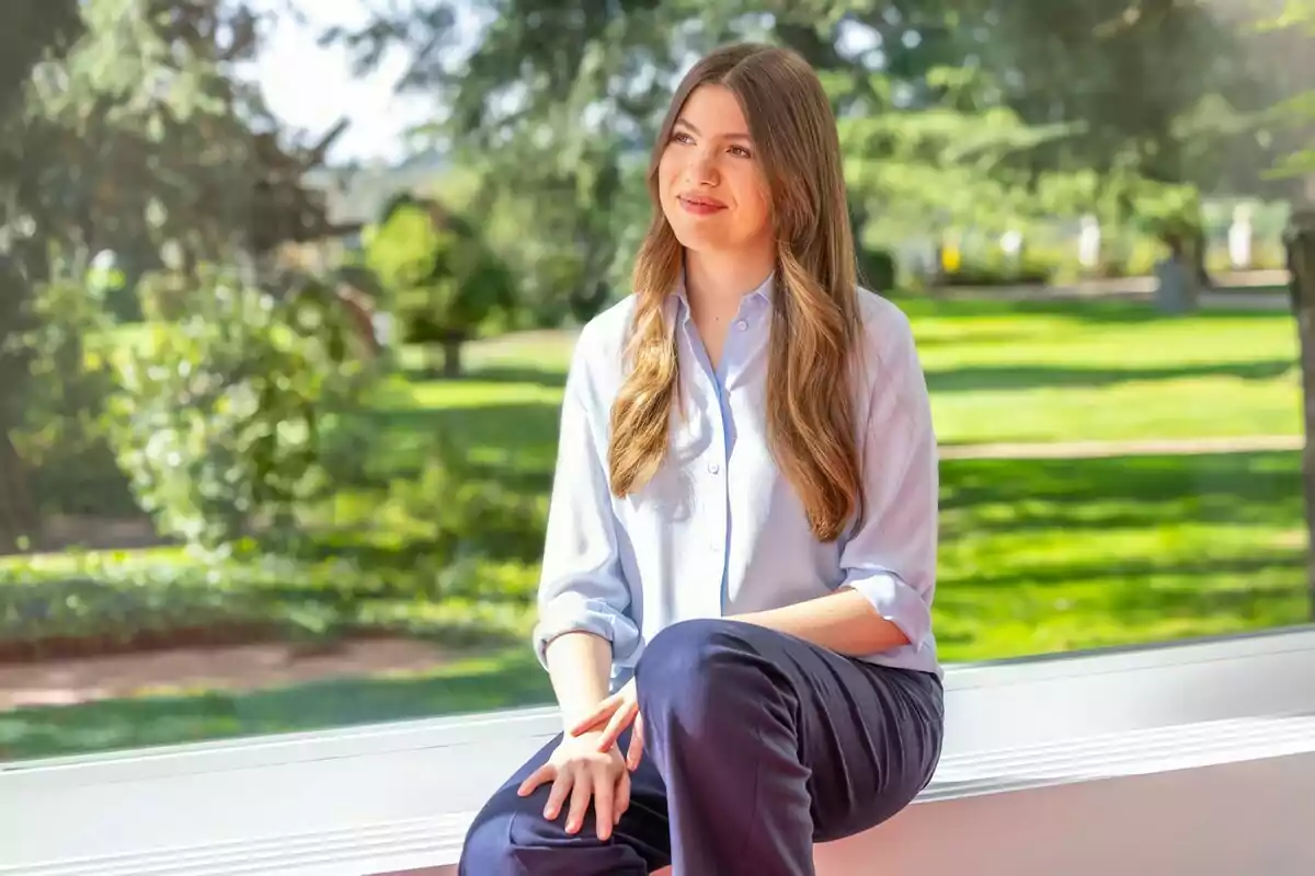 Infanta Sofía sitting by a window with a green garden background. Infanta Sofía sitting by a window with a green garden background.