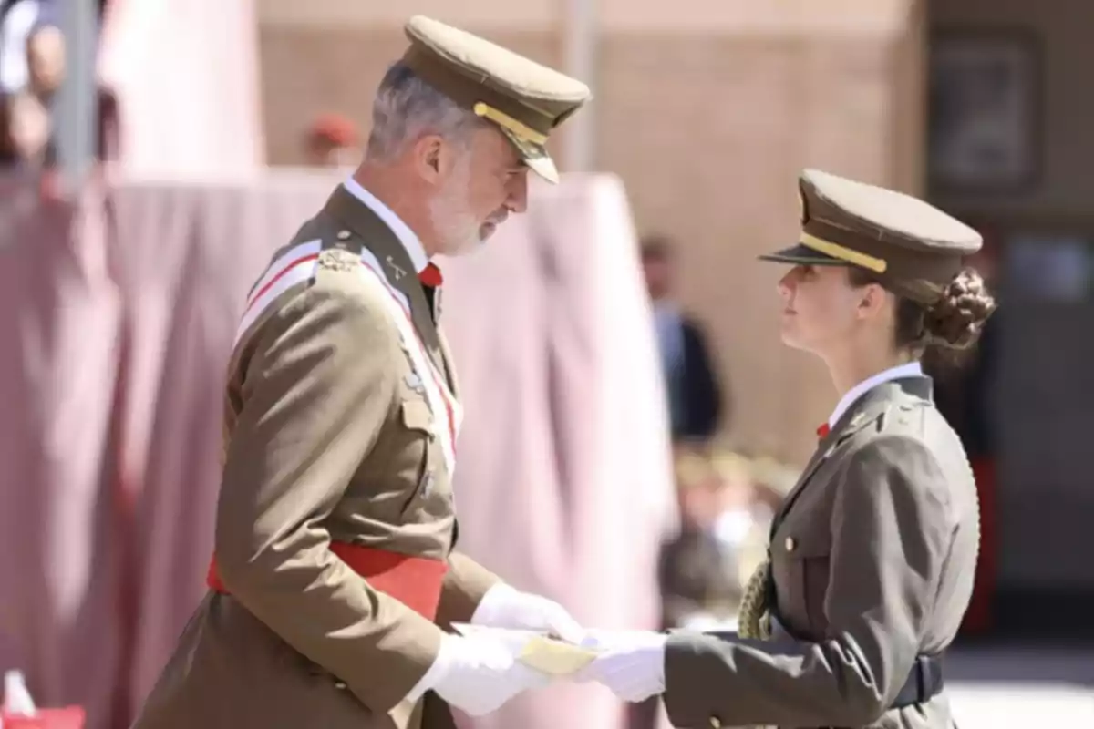 Dues persones en uniforme militar es lliuren un document durant una cerimònia.