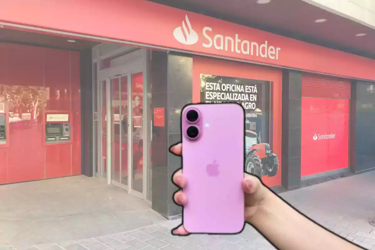 Una persona sosté un iPhone 16 davant d'una sucursal bancària de Santander.