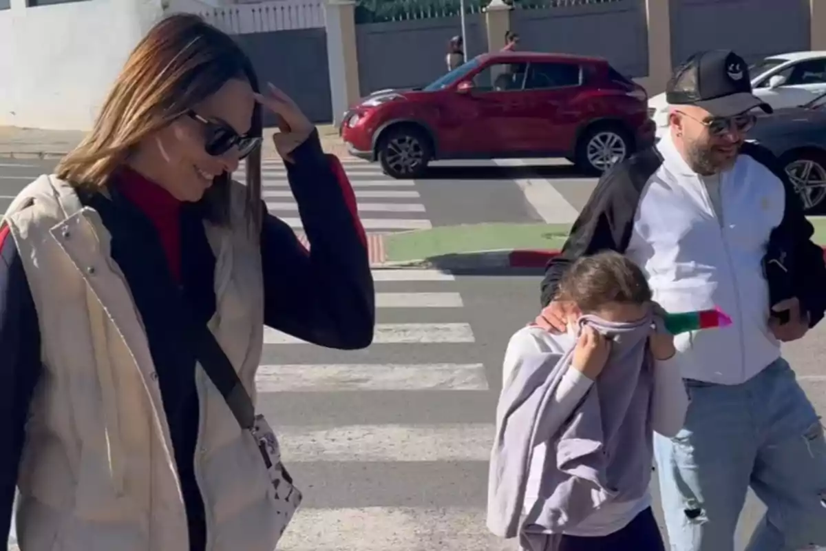 Irene Rosales i Kiko Rivera caminen per un pas de vianants amb una nena que es cobreix la cara amb una peça de roba. Irene Rosales i Kiko Rivera caminen per un pas de vianants amb una nena que es cobreix la cara amb una peça de roba.