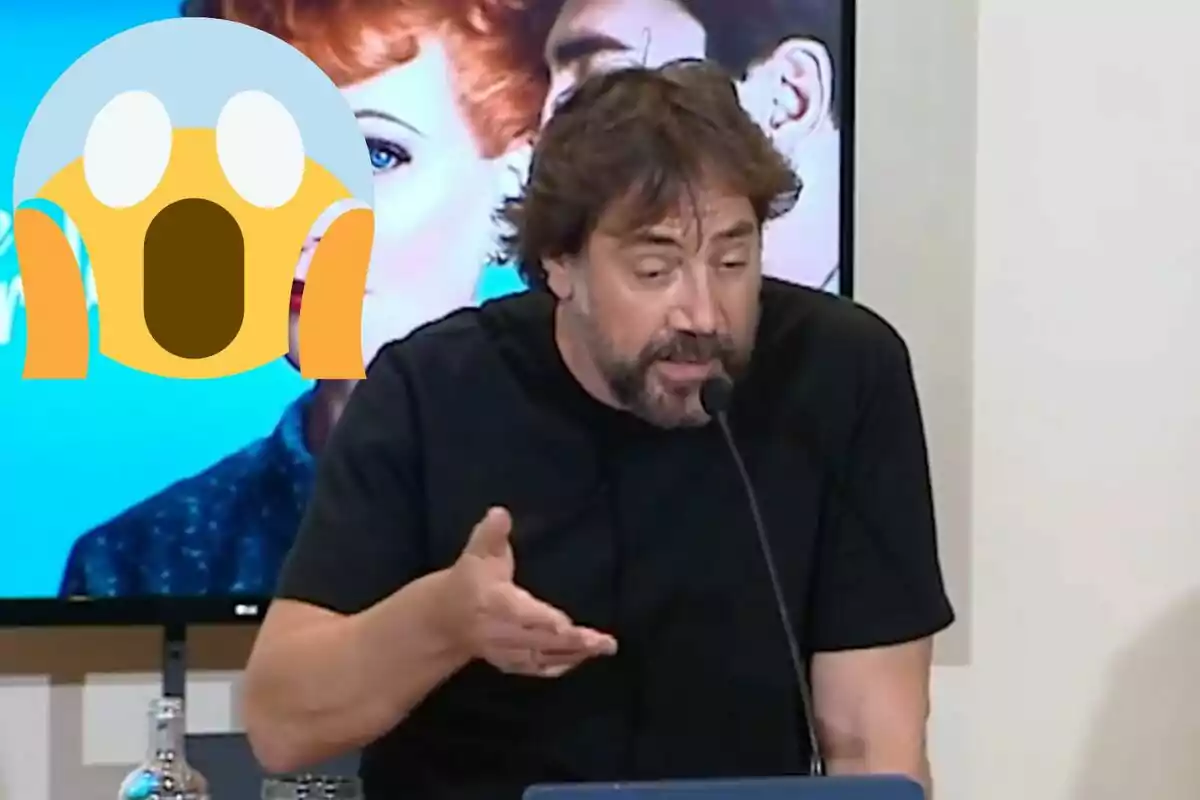 Un home amb barba i cabell fosc parla en un micròfon mentre gesticula amb la mà, amb un emoji de sorpresa superposat a la imatge.