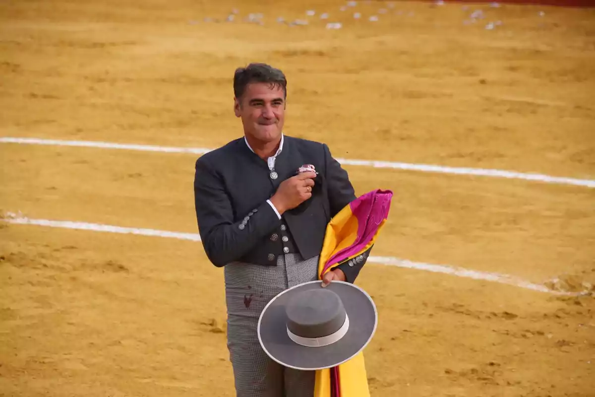 Jesulín de Ubrique a la plaça de toros sostenint un capot i un barret. Jesulín de Ubrique a la plaça de toros sostenint un capot i un barret.