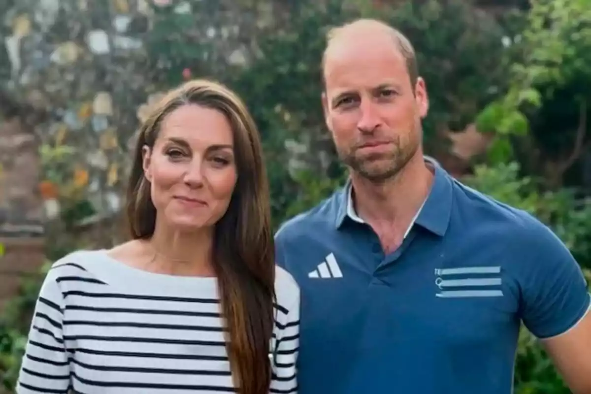 Kate Middleton in a striped T-shirt and Prince William in a blue T-shirt pose together outdoors against a backdrop of greenery and a stone wall. Kate Middleton in a striped T-shirt and Prince William in a blue T-shirt pose together outdoors against a backdrop of greenery and a stone wall.