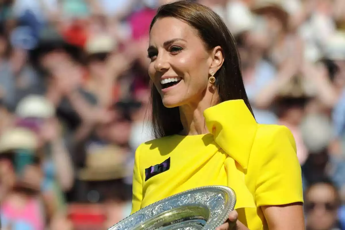 Kate Middleton rient amb un vestit groc i un plat de plata a les mans Kate Middleton rient amb un vestit groc i un plat de plata a les mans