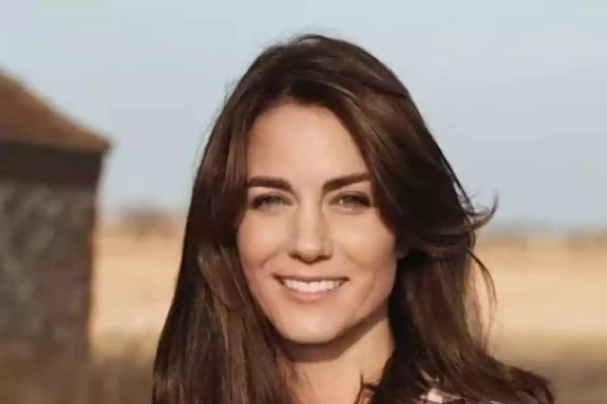 Una mujer sonriente con cabello castaño oscuro en un entorno al aire libre. Una mujer sonriente con cabello castaño oscuro en un entorno al aire libre.