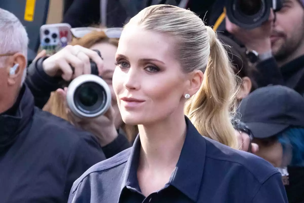 Kitty Spencer with her hair in a ponytail is surrounded by photographers taking pictures of her.