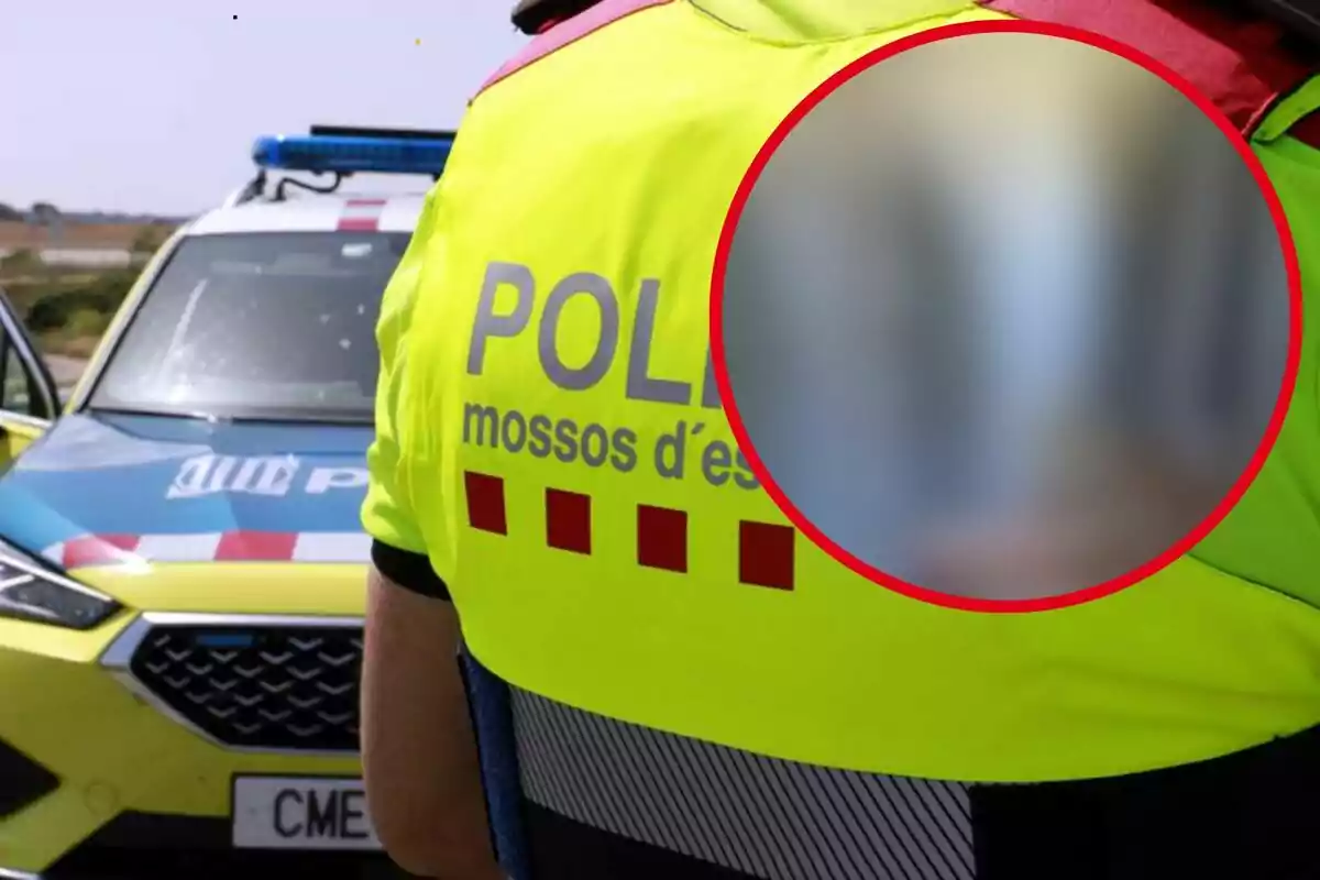 Policía de los Mossos d'Esquadra de espaldas con un coche patrulla al fondo y un círculo borroso en la imagen.