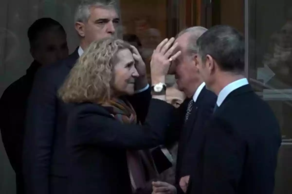 Una mujer tocando la frente de un hombre mayor mientras otras personas observan. Una mujer tocando la frente de un hombre mayor mientras otras personas observan.