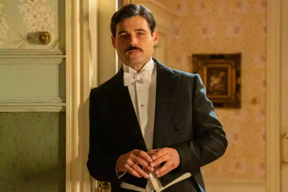 Manuel con bigote y esmoquin de pie junto a una puerta, sosteniendo un vaso. Captura de 'La Promesa' Manuel con bigote y esmoquin de pie junto a una puerta, sosteniendo un vaso. Captura de 'La Promesa'