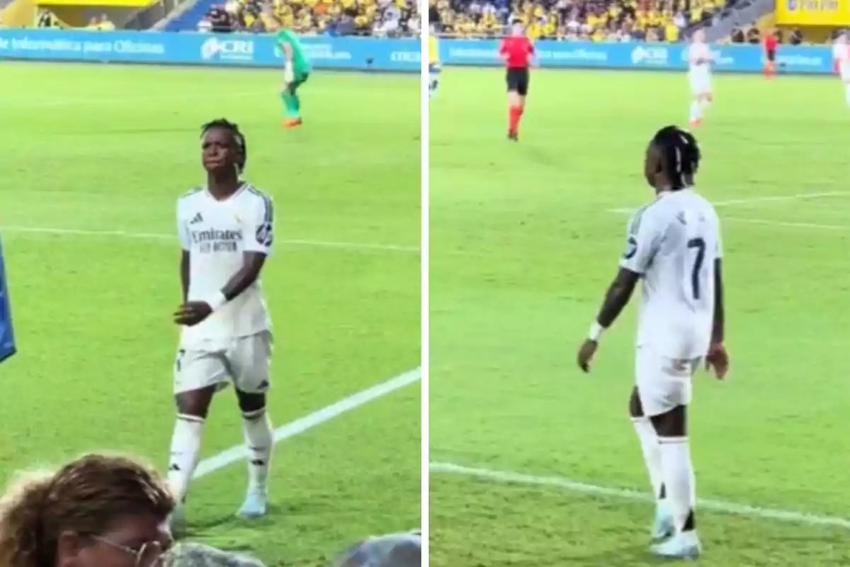 Un jugador de futbol amb l?uniforme blanc del Reial Madrid camina pel camp durant un partit, amb el públic i altres jugadors visibles al fons.