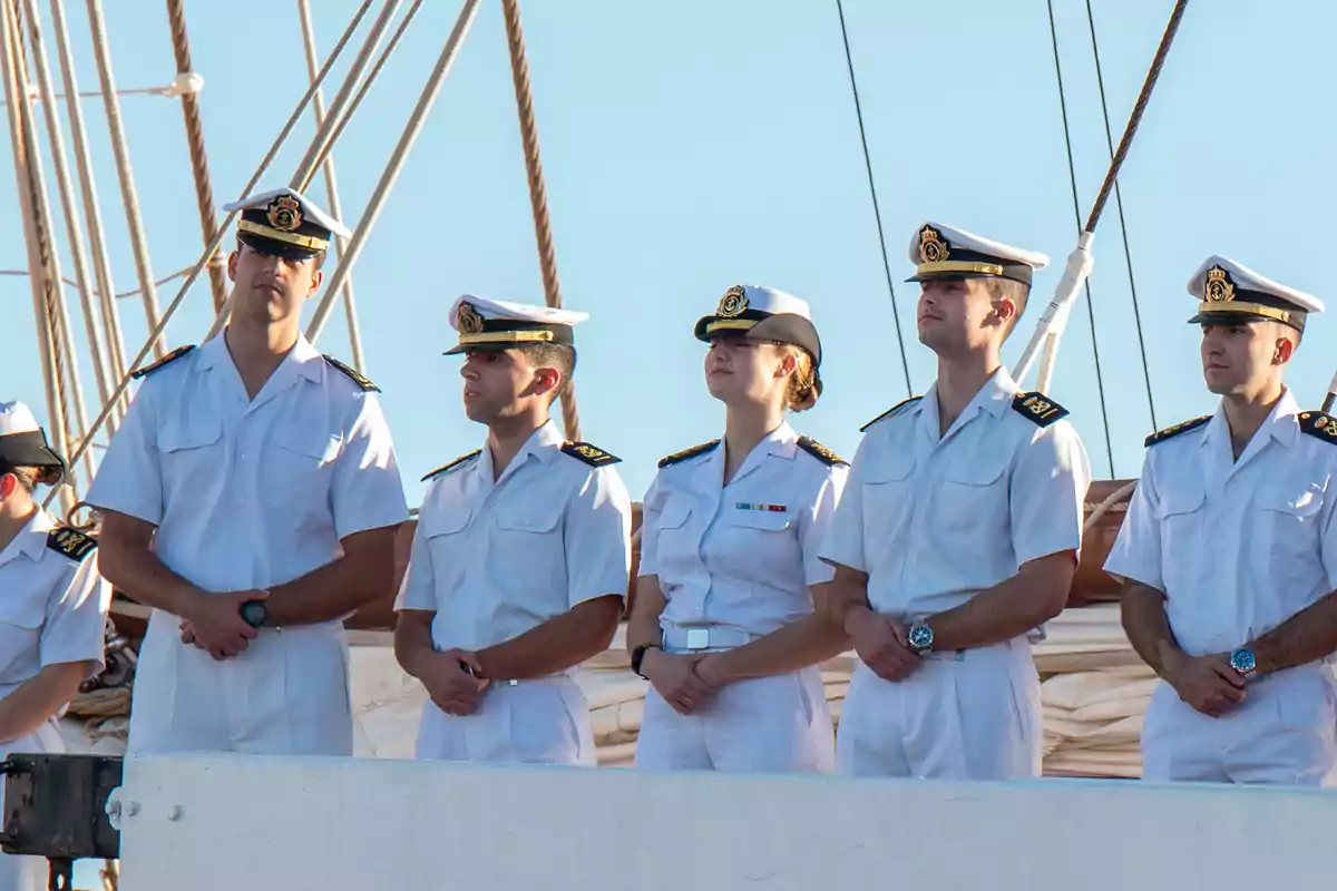Leonor y sus compañeros en uniforme blanco de pie en la cubierta de un barco. Leonor y sus compañeros en uniforme blanco de pie en la cubierta de un barco.