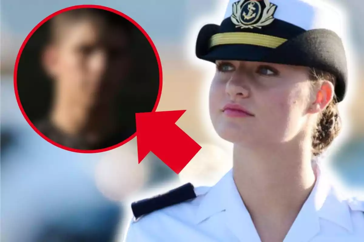 Dona amb uniforme de marina i gorra blanca mentre una figura masculina desenfocada apareix en un cercle vermell amb una fletxa que assenyala cap a ella
