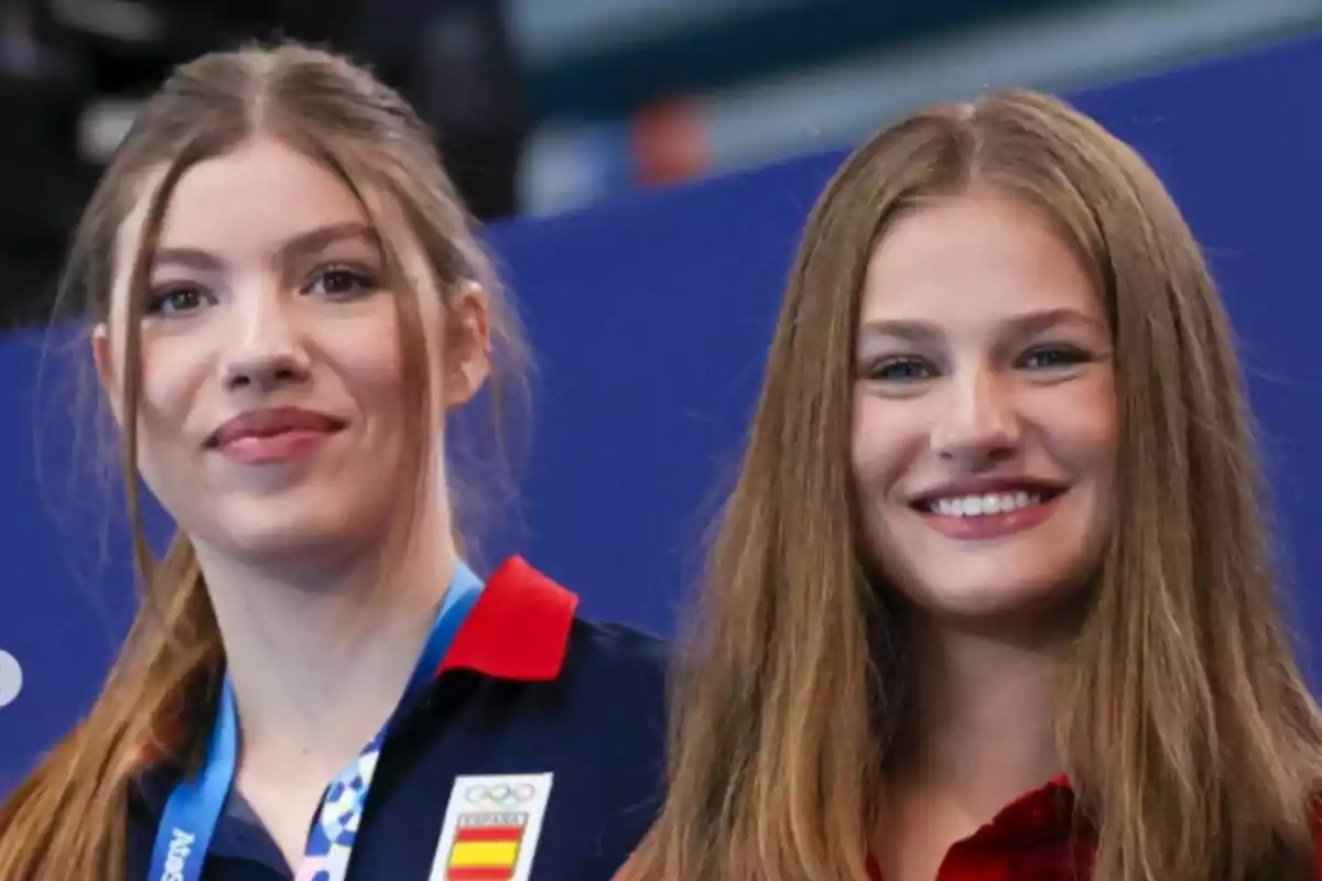 Dos jóvenes sonrientes, una de ellas lleva una medalla y un uniforme con el escudo de España. Dos jóvenes sonrientes, una de ellas lleva una medalla y un uniforme con el escudo de España.