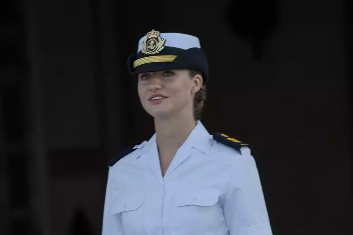 Leonor con uniforme militar blanco y gorra con insignia dorada. Leonor con uniforme militar blanco y gorra con insignia dorada.