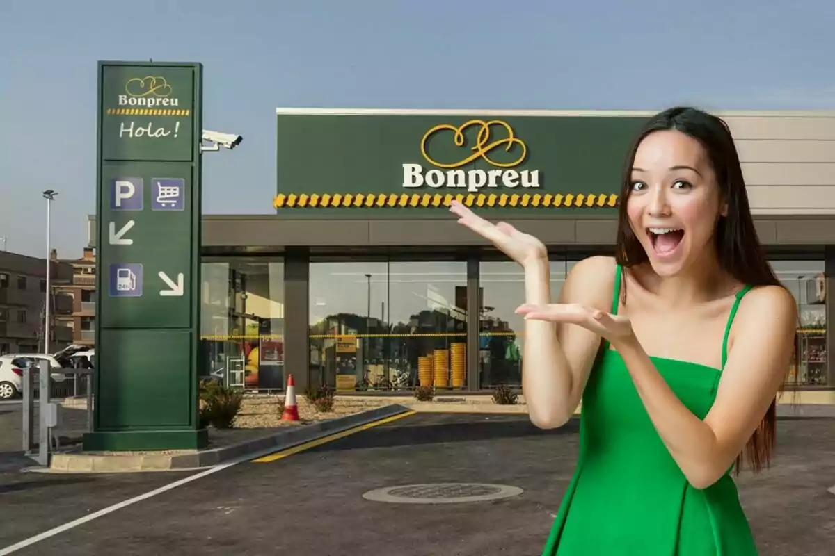 Una mujer sonriente con un vestido verde señala hacia un supermercado Bonpreu con un cartel que dice "Hola!" y muestra símbolos de estacionamiento, carrito de compras y gasolinera.