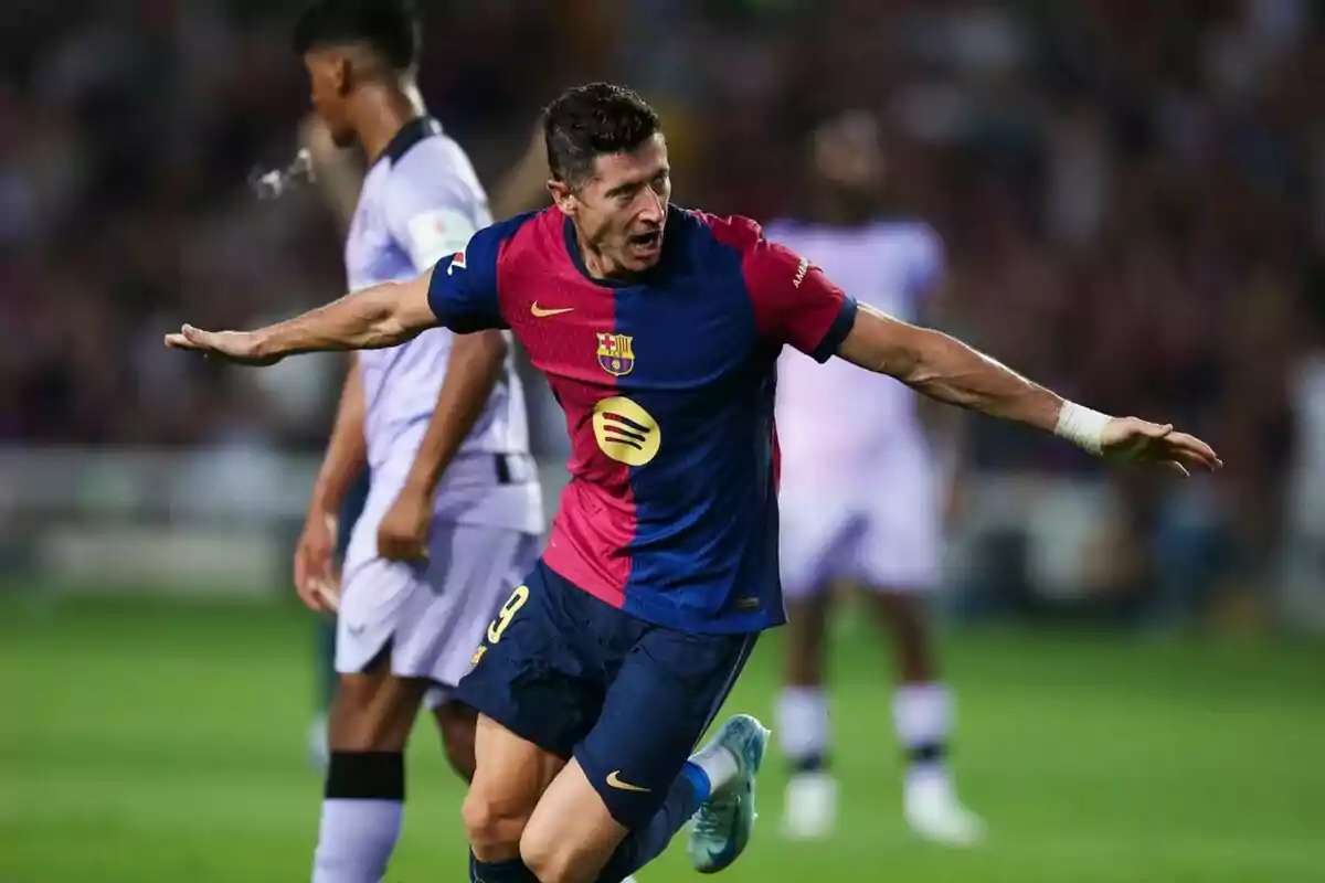 Jugador de futbol celebrant un gol amb els braços estesos, vestint l'uniforme del FC Barcelona.