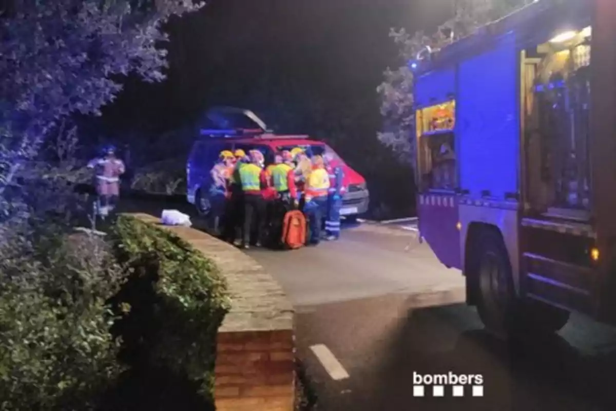 Un grup de bombers treballen al costat d?un vehicle d?emergència en una carretera durant la nit. Un grup de bombers treballen al costat d?un vehicle d?emergència en una carretera durant la nit.