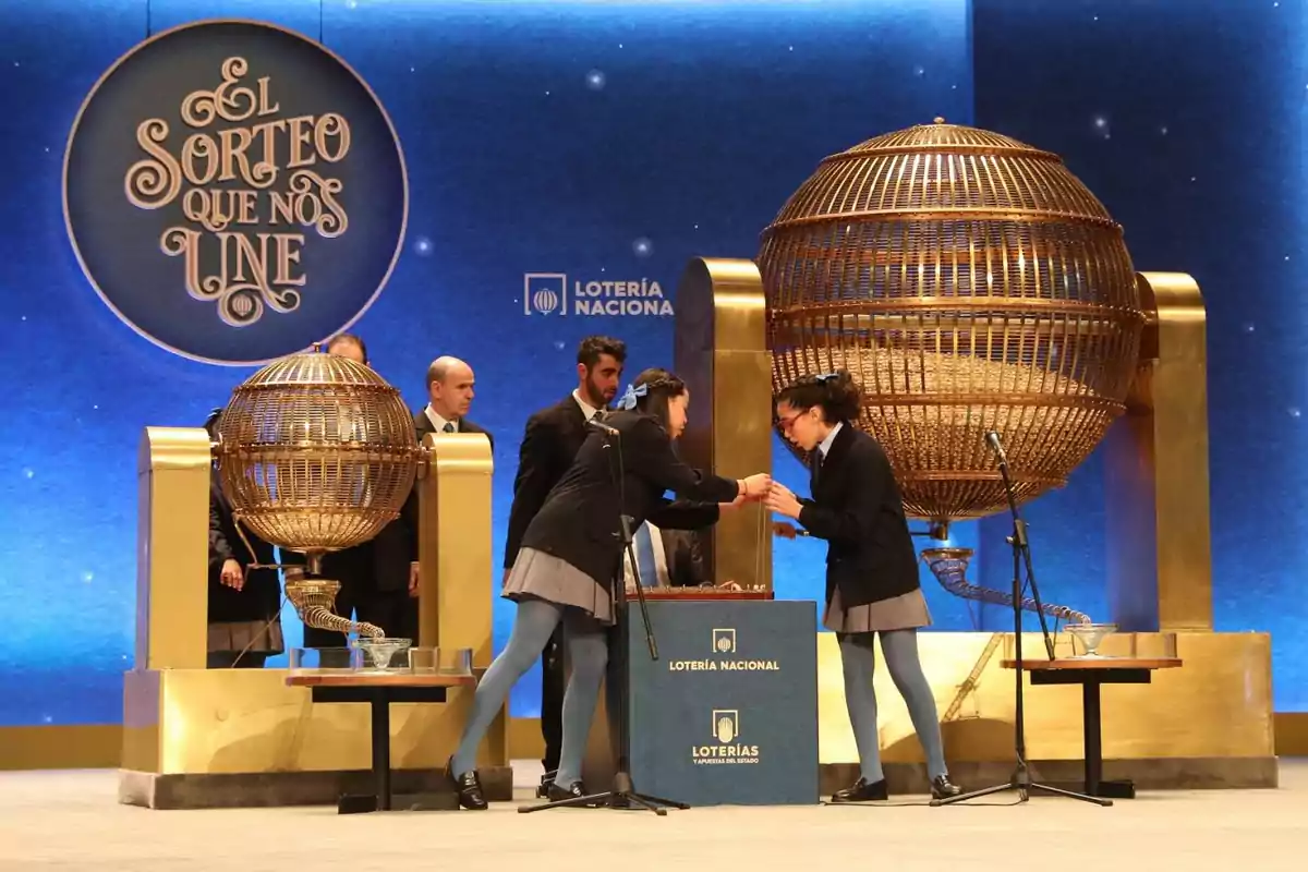 Nenes de Sant Idelfons extraient les boles dels bombos durant el sorteig de la Loteria de Nadal