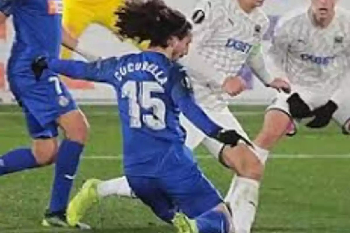Un jugador de fútbol con el número 15 en su camiseta azul está en acción durante un partido, rodeado de otros jugadores con uniformes blancos. Un jugador de fútbol con el número 15 en su camiseta azul está en acción durante un partido, rodeado de otros jugadores con uniformes blancos.