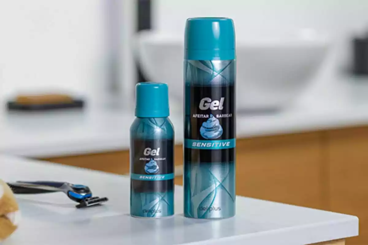Dos envases de gel de afeitar sobre una encimera junto a una maquinilla de afeitar. Dos envases de gel de afeitar sobre una encimera junto a una maquinilla de afeitar.