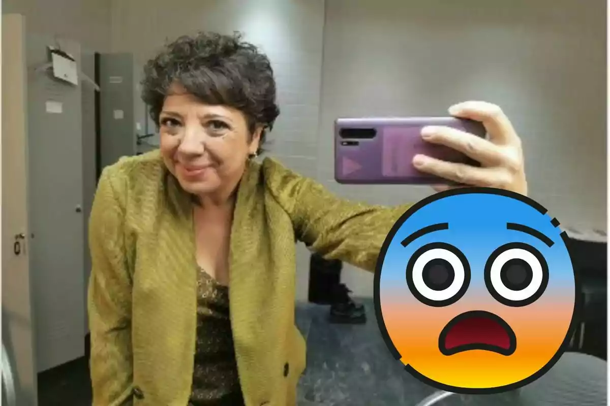 Una mujer con chaqueta dorada se toma una selfie en un espejo, mientras un emoji de cara sorprendida cubre parte de la imagen.