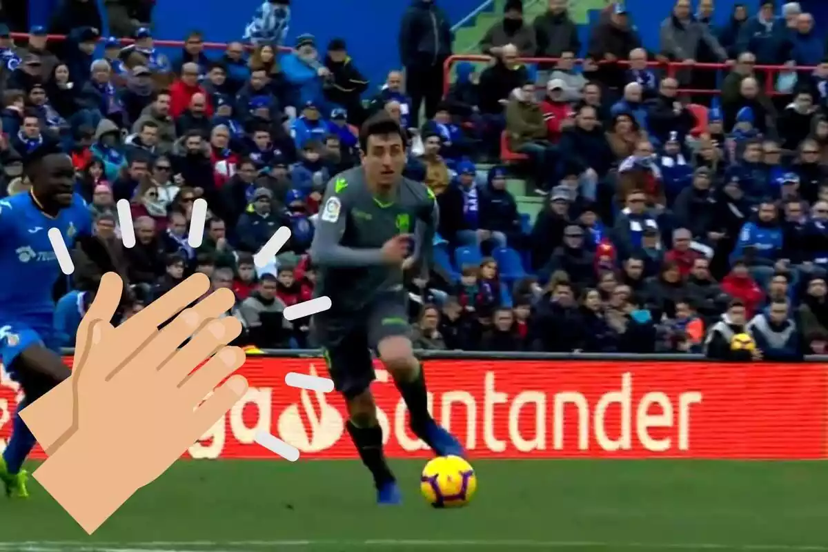 Muntatge amb una imatge de Mikel Oyarzábal durant un partit de futbol amb la Reial Societat ia la cantonada inferior esquerra una emoticona de mans aplaudint