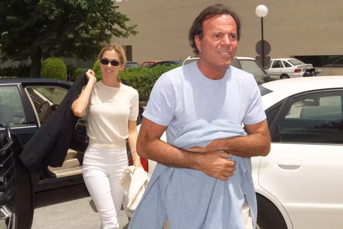 Miranda Rijnsburger y Julio Iglesias caminando cerca de un coche en un día soleado. Miranda Rijnsburger y Julio Iglesias caminando cerca de un coche en un día soleado.