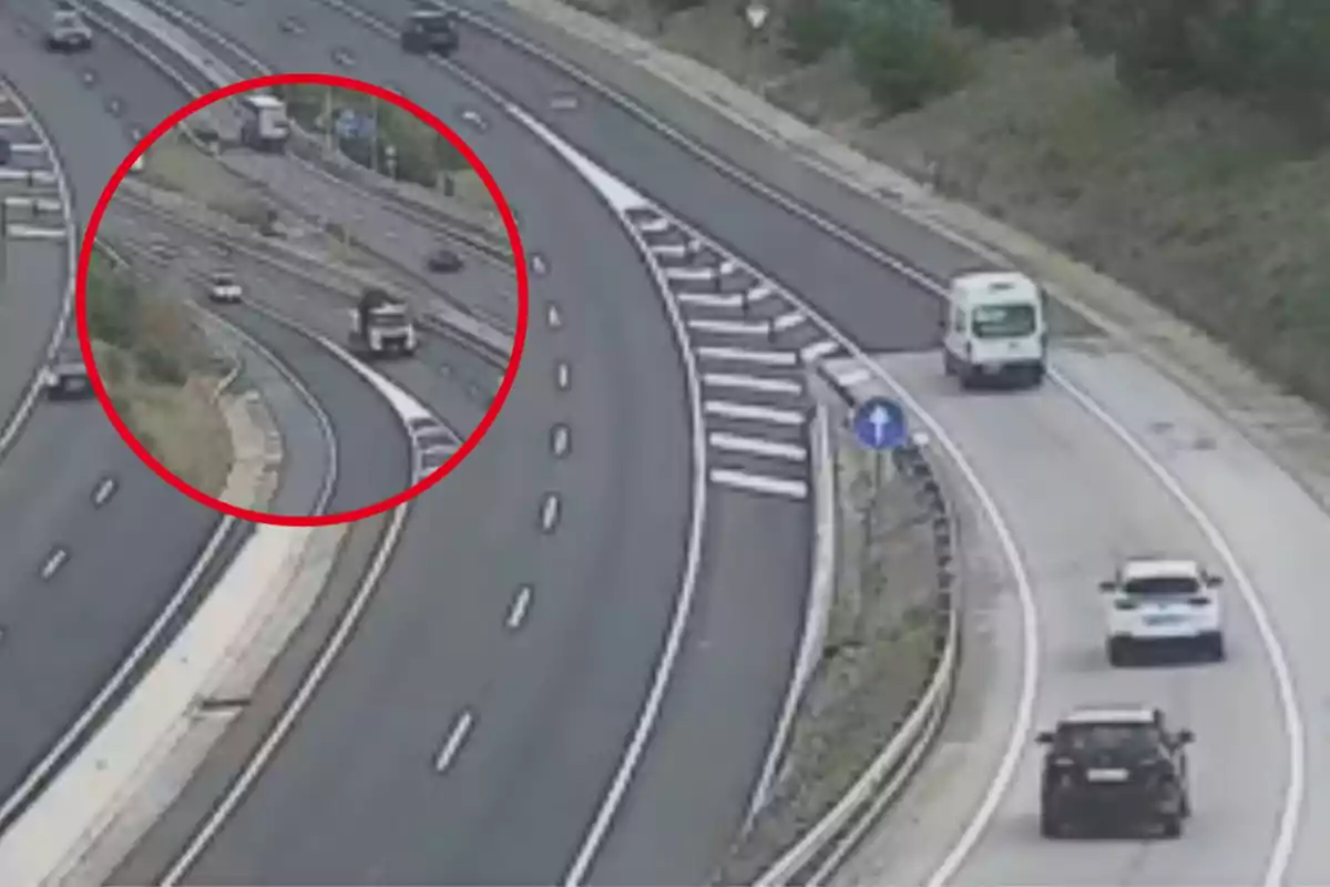 Una carretera amb diversos carrils i vehicles circulant, destacant un camió a un carril separat per un cercle vermell.